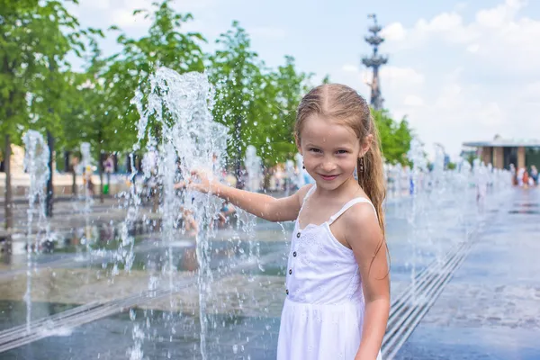 Niña divertirse en la fuente de calle abierta en el día de verano caliente —  Fotos de Stock