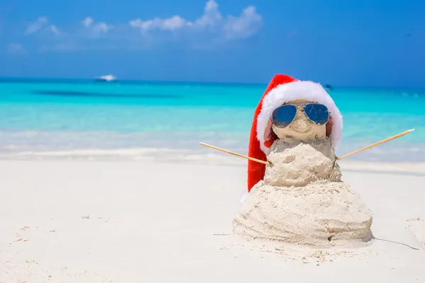 Homem de neve arenoso com chapéu de Santa vermelho na praia caribenha branca — Fotografia de Stock