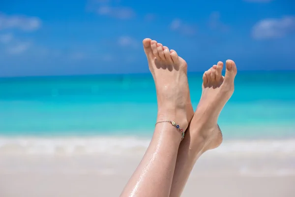 Close up van vrouwelijke voeten op wit zandstrand — Stockfoto