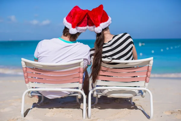 Jong koppel in santa hoeden genieten van strandvakantie — Stockfoto