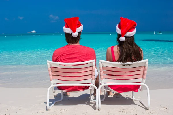 Gelukkige romantisch paar in rode santa hoeden op tropisch strand — Stockfoto