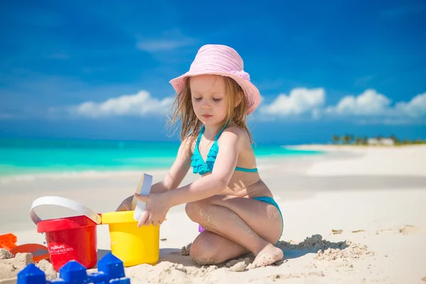 愛らしい女の子遊びますとともにおもちゃでビーチ休暇 — ストック写真