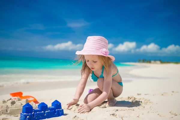 Malá roztomilá dívka hraje s hračkami na pláži během tropické dovolené — Stock fotografie