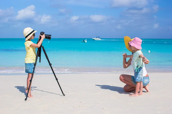 Little girl making photo of her mom and sister at the beach — Stock Photo, Image