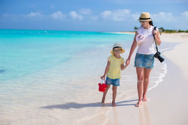Kumsalda yürüyen kamera ile küçük kız ve genç anne — Stok fotoğraf