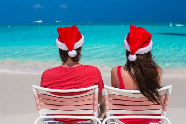 Happy romantic couple in red Santa Hats at tropical beach — Stock Photo, Image
