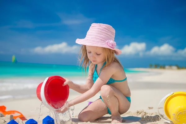 Schattig klein meisje spelen met speelgoed op strand vakantie — Stockfoto