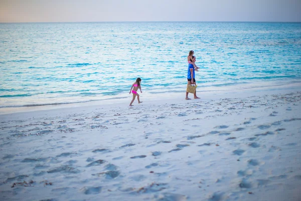 Счастливый отец и его милые маленькие дочери на пляже — стоковое фото