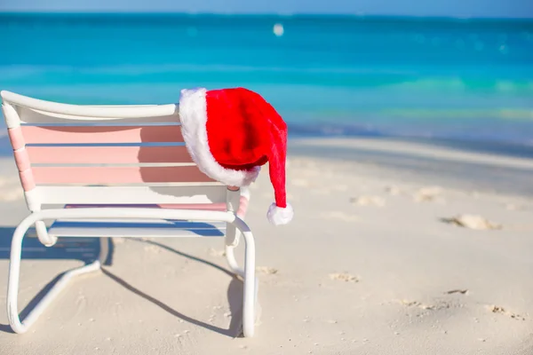 Red Santa hat on beach chair — Stock Photo, Image