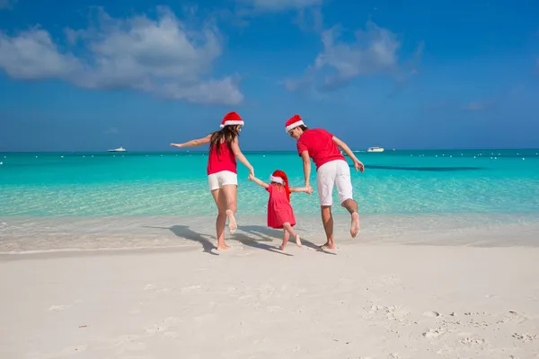 Happy family in Santa Hats on beach during caribbean vacation — Stock Photo, Image