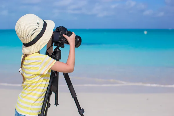 Kleines Mädchen schießt mit Kamera auf Stativ im Sommerurlaub — Stockfoto