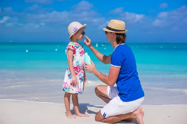 Father apply sunblock cream on his little daughter nose — Stock Photo, Image