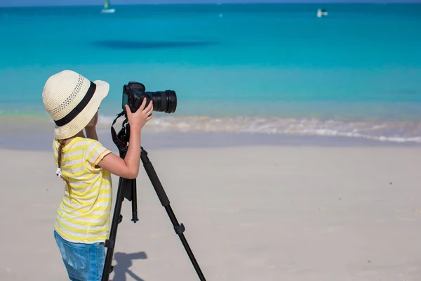 Little girl shooting with camera on tripod during her summer vacation — Stock Photo, Image