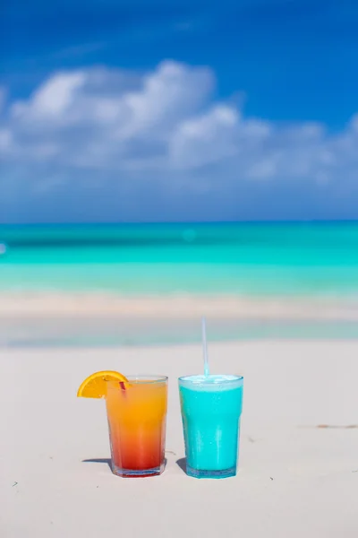Two tasty cocktails on the white sandy beach — Stock Photo, Image