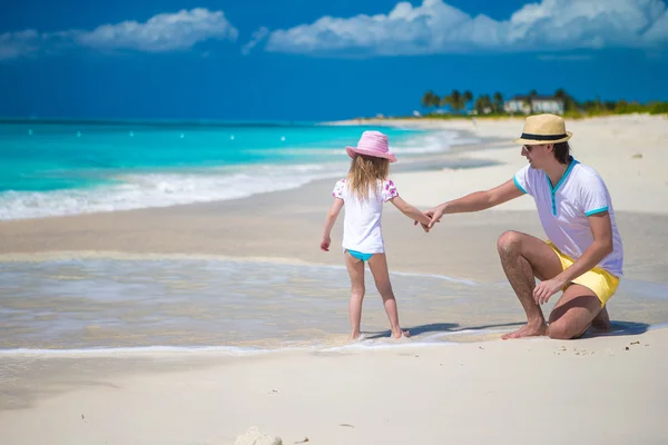 Glücklicher Vater und seine süße kleine Tochter am Strand — Stockfoto