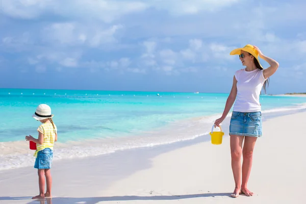 Niña y madre joven en la playa tropical durante las vacaciones de verano —  Fotos de Stock