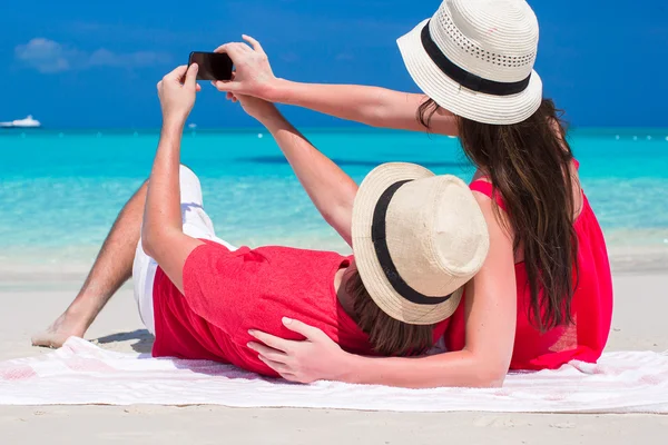 Casal feliz tirando uma foto na praia tropical — Fotografia de Stock