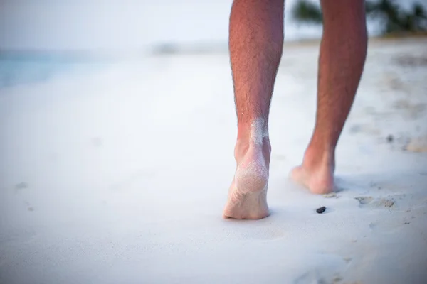Mężczyzna nogi na białej, piaszczystej plaży z bliska — Zdjęcie stockowe