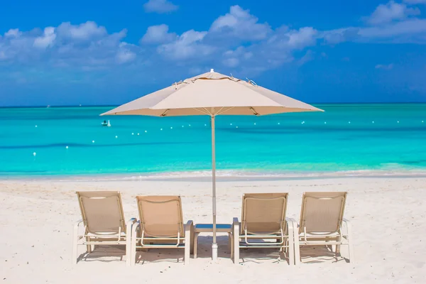 白色遮阳伞和在地处热带的海滩日光浴浴床 — 图库照片