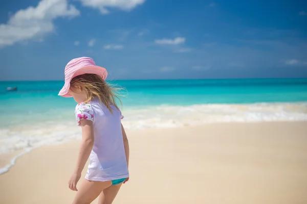 Adorable niña jugando en aguas poco profundas en la playa perfecta —  Fotos de Stock