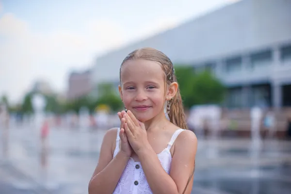 Niña divertirse en la fuente de calle abierta en el día de verano caliente — Foto de Stock