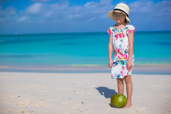 Rozkošná holčička s kokosem na bílé pláži bavit — Stock fotografie