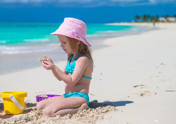 Adorable niña jugando con arena en una playa tropical perfecta —  Fotos de Stock