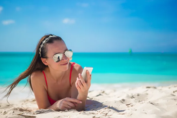 Telefonunu egzotik Plajı olan kadın — Stok fotoğraf