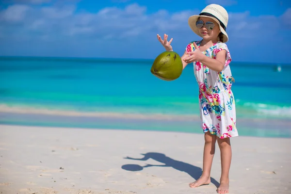 Entzückendes kleines Mädchen mit Kokosnuss am weißen Strand haben Spaß — Stockfoto