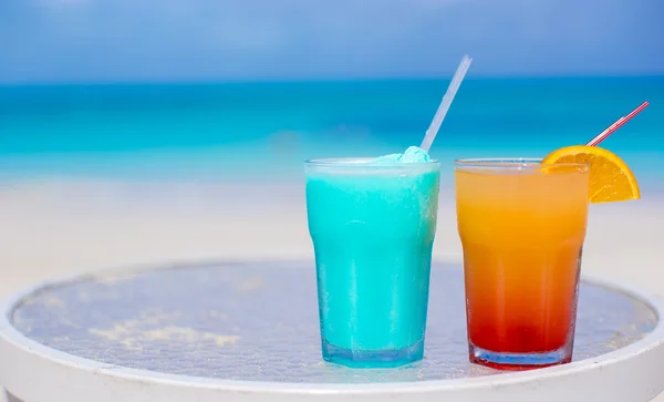 Two tasty cocktails on the white sandy beach — Stock Photo, Image