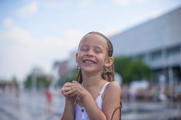 Niña divertirse en la fuente de calle abierta en el día de verano caliente —  Fotos de Stock