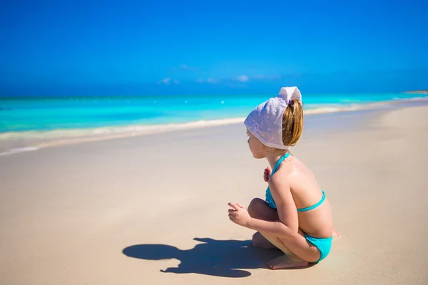 Bedårande liten flicka som leker på grunt vatten på perfekt beach — Stockfoto