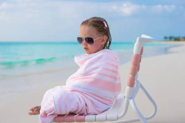 Adorable little girl in sunglasses covered with towel at tropical beach — Stock Photo, Image