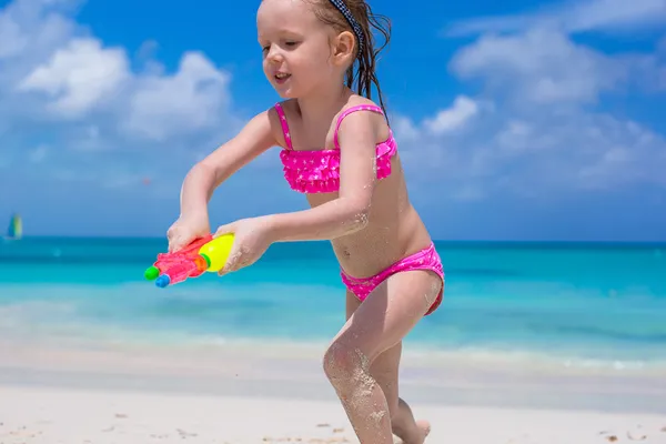 Gadis kecil yang bahagia bermain dengan mainan di pantai selama liburan — Stok Foto
