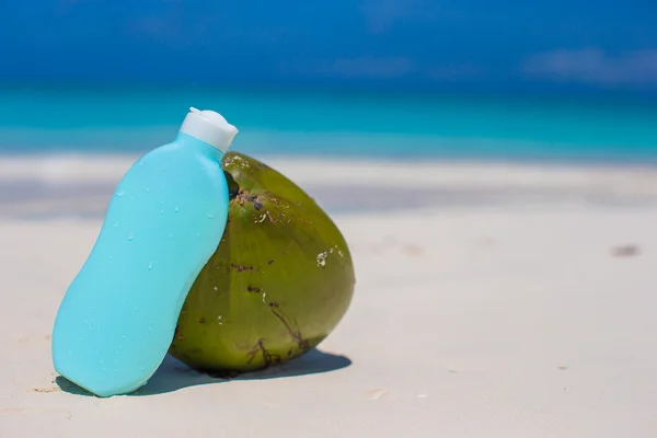 Kokos och solkräm på vita sand — Stockfoto