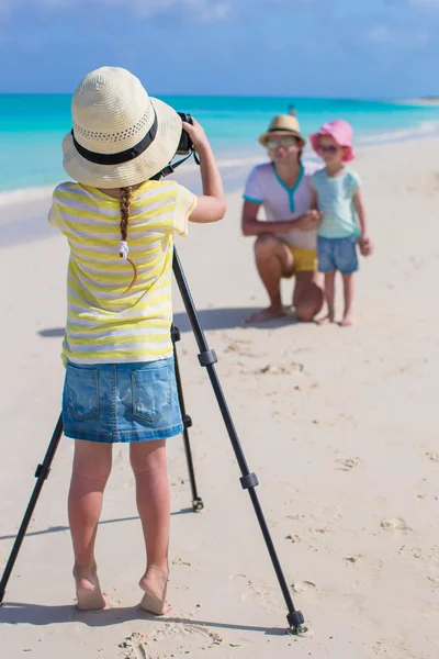 Niña haciendo foto de su padre y su hermana en la playa — Foto de Stock