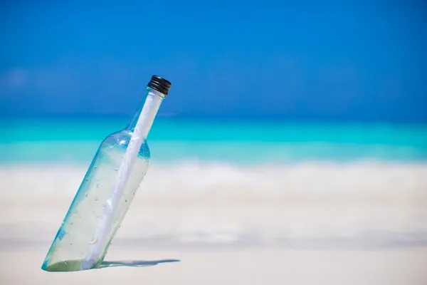 Bouteille avec un message enfoui dans le sable blanc — Photo