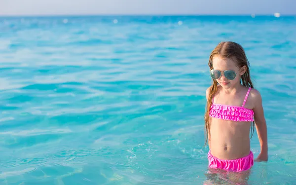 Entzückendes kleines Mädchen schwimmt im türkisfarbenen Wasser — Stockfoto