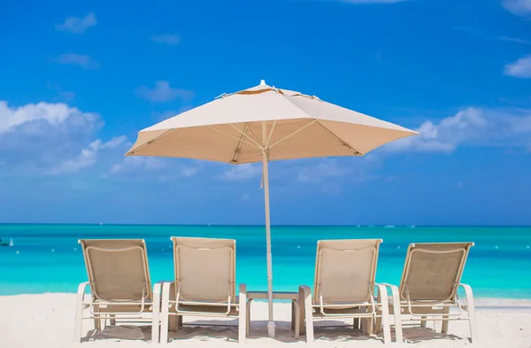 Guarda-chuvas brancos e espreguiçadeiras na praia tropical — Fotografia de Stock