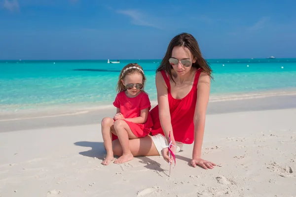Jonge moeder en meisje hebben plezier op tropisch strand — Stockfoto