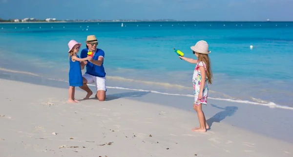 Malá dívka si hraje s rodinou na pláži — Stock fotografie