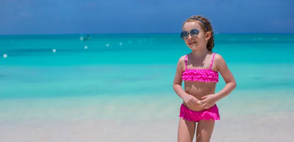 Nettes kleines Mädchen mit Sonnenbrille am Strand während der Sommerferien — Stockfoto