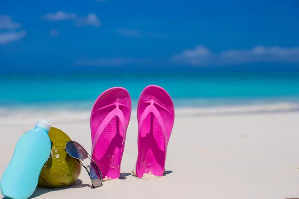 Flipflops, Kokosnuss und Sonnencreme auf weißem Sand — Stockfoto