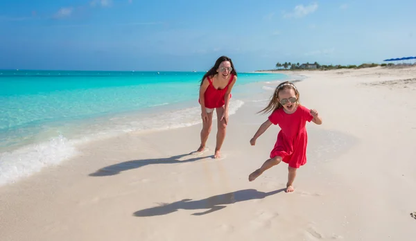 Young mother and little girl have fun at tropical beach — Stock Photo, Image