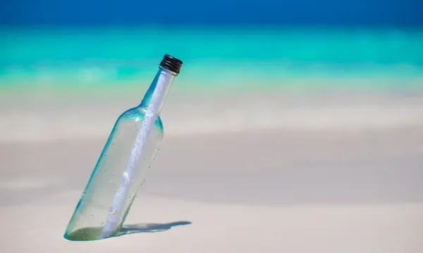 Bottle with a message buried in the white sand — Stock Photo, Image