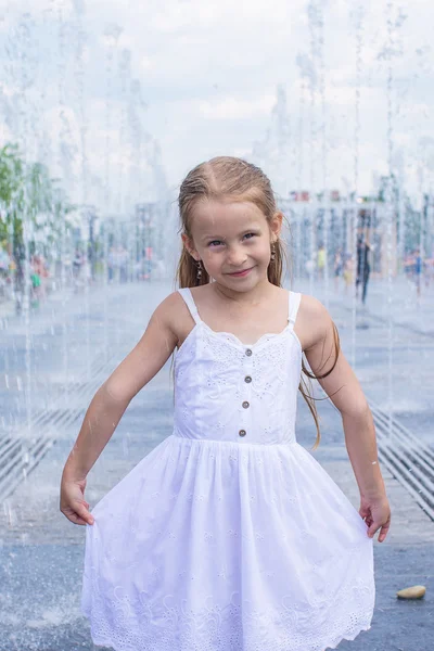 Niña linda divertirse en la fuente de calle abierta en el día de verano caliente — Foto de Stock