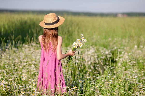 Feliz niño en el campo. Hermosa chica en vestido con un sombrero de paja — Foto de Stock