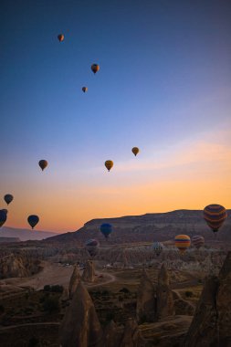 Kapadokya, Türkiye 'de gökyüzünde parlak sıcak hava balonları