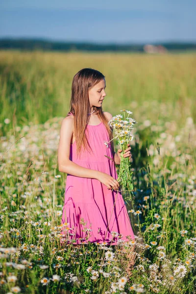 Criança feliz no terreno. Menina bonita no vestido em um chapéu de palha — Fotografia de Stock