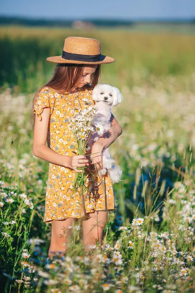 Criança feliz no terreno. Menina bonita no vestido em um chapéu de palha — Fotografia de Stock